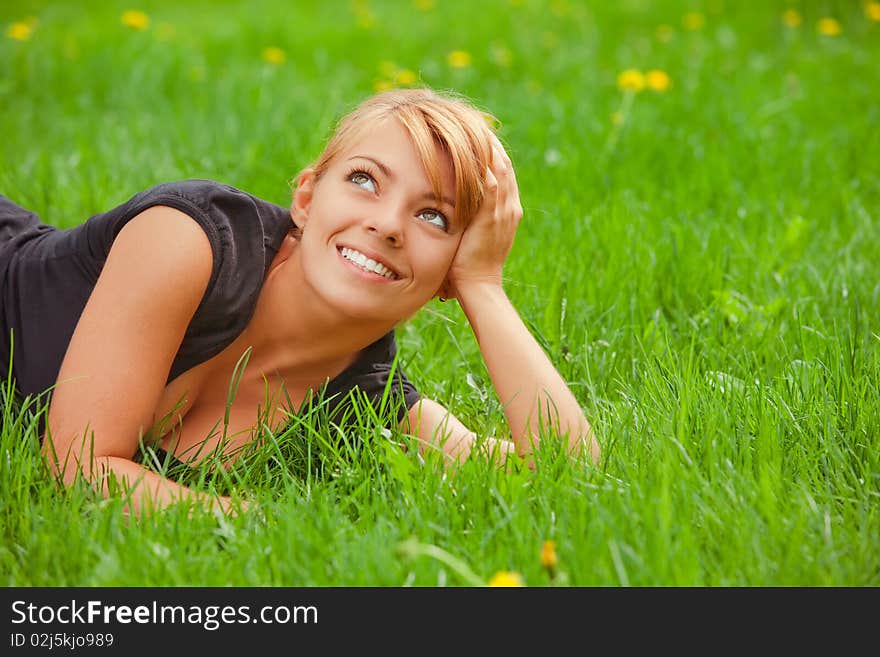 Young pretty girl lying on green grass. Young pretty girl lying on green grass