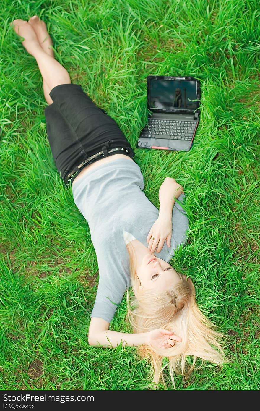 Series. The beautiful business woman with the laptop has a rest in the field