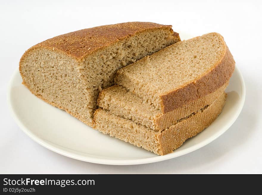 The bread at white plate close-up on a white background. The bread at white plate close-up on a white background