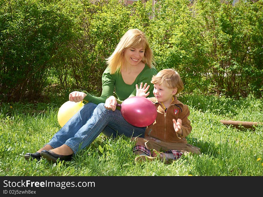 Mum with the son are played with balls in the spring on the nature. Mum with the son are played with balls in the spring on the nature