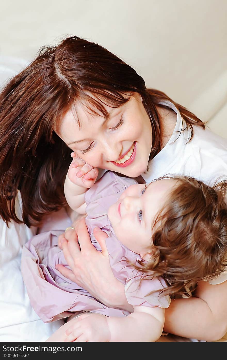 Cute baby girl strokes her mother's cheek