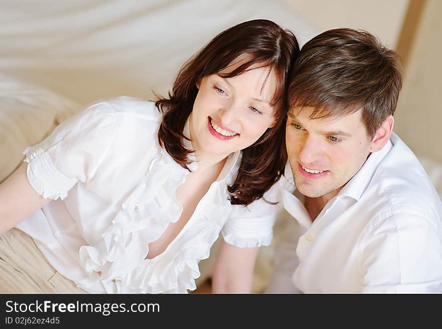 Beautiful young couple close up smiles and looks at someone. Beautiful young couple close up smiles and looks at someone