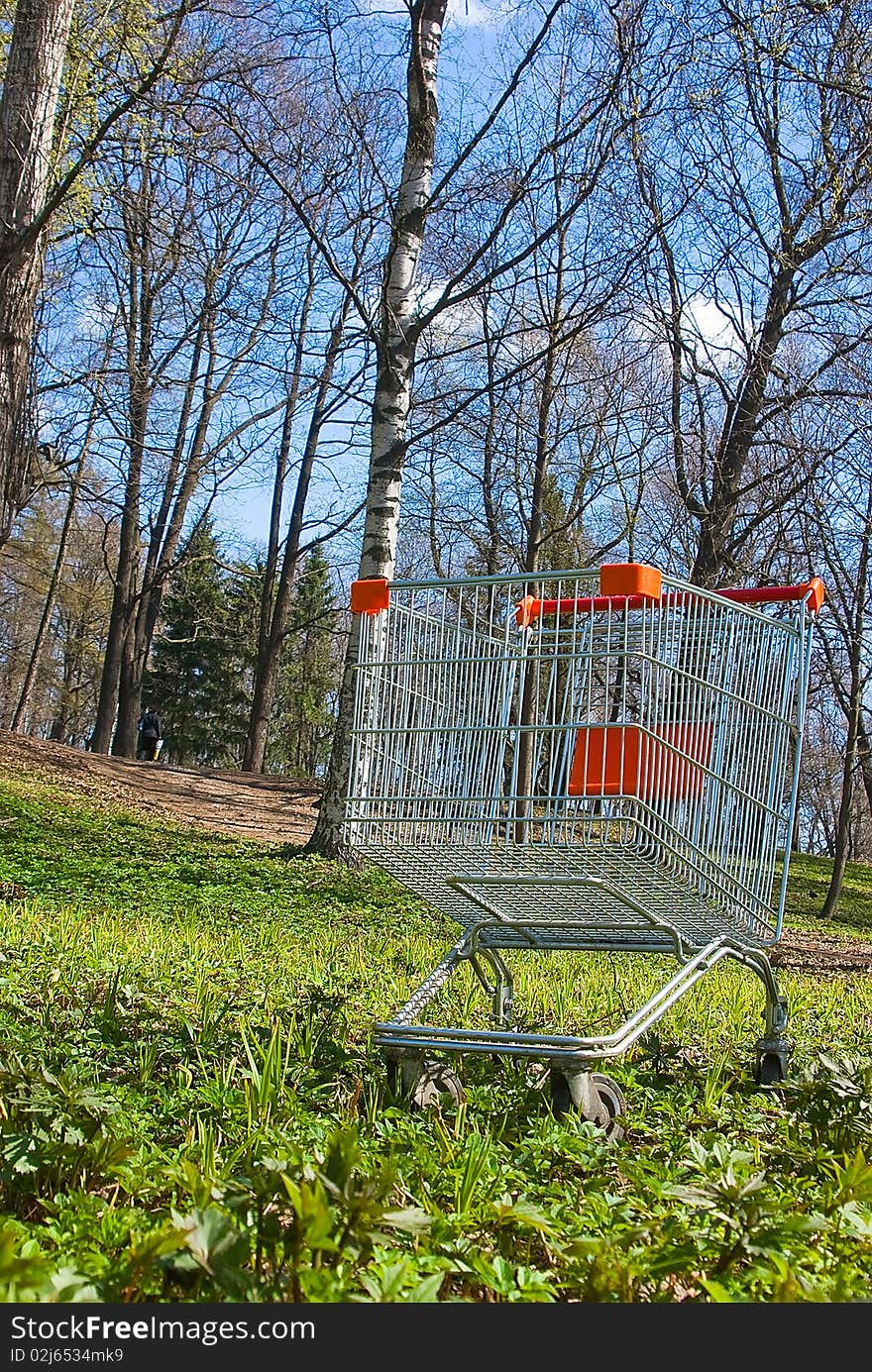 The hand cart from a supermarket on a green grass close up