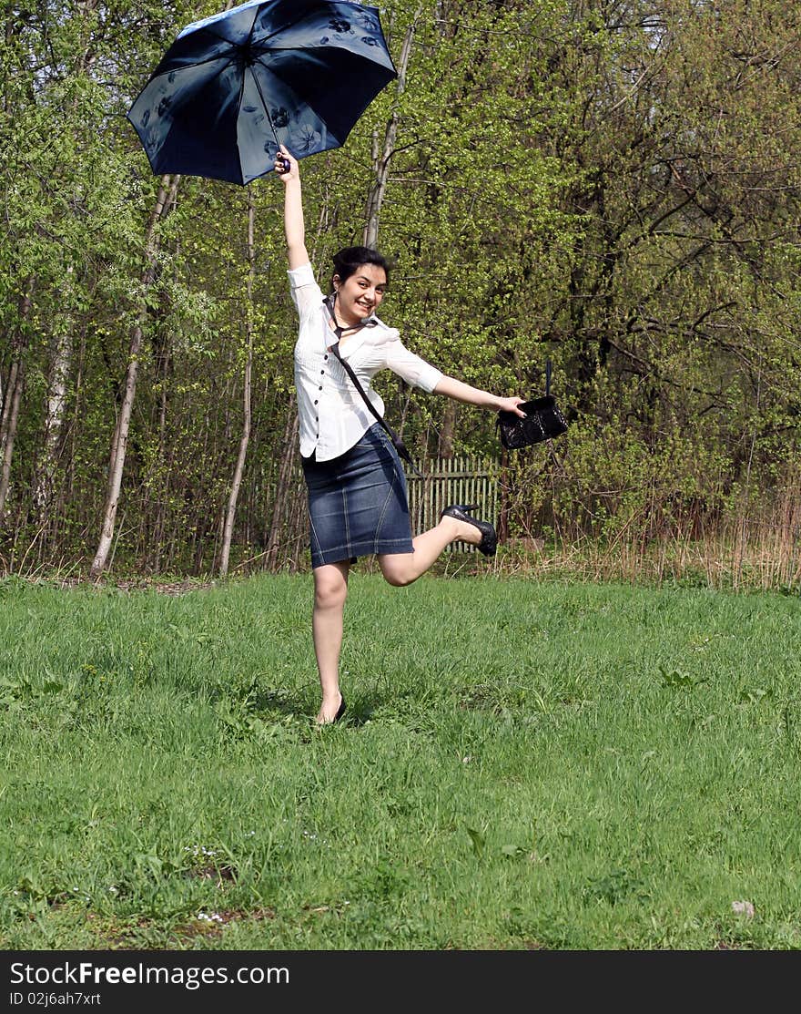 Business woman jumping with umbrella