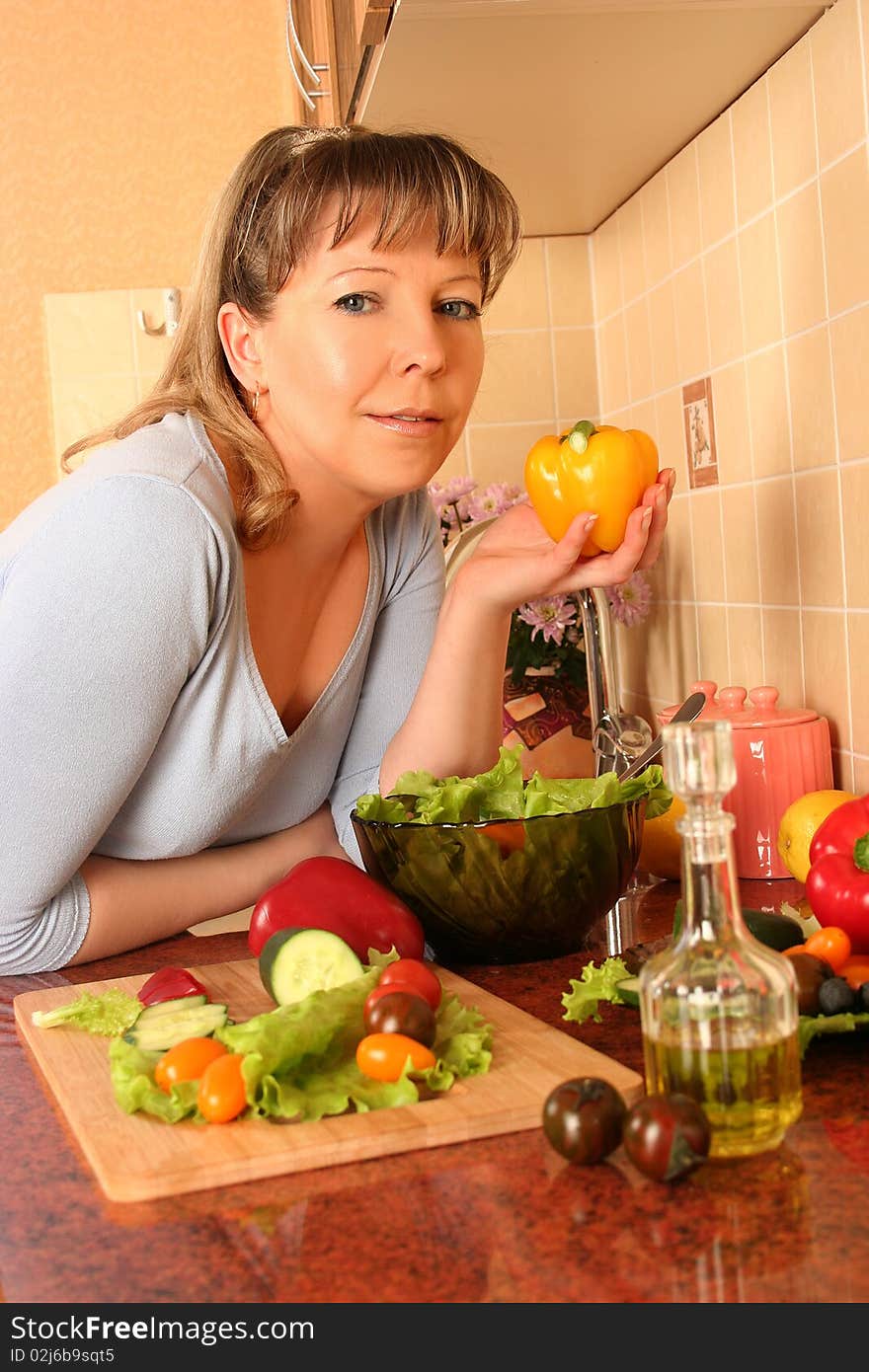 Adult woman preparing salad at domestic kitchen