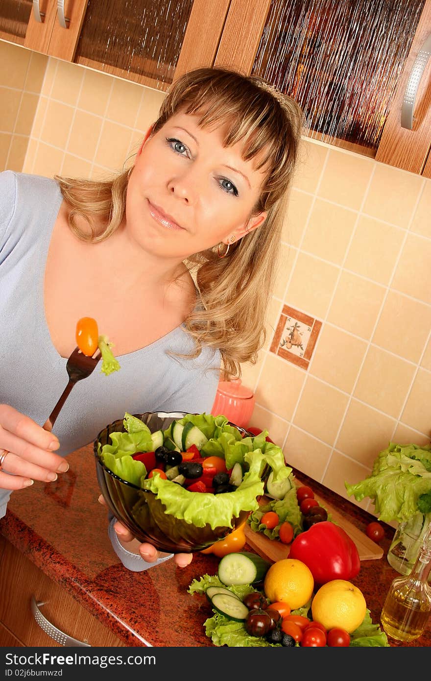 Adult woman preparing salad at domestic kitchen. Adult woman preparing salad at domestic kitchen