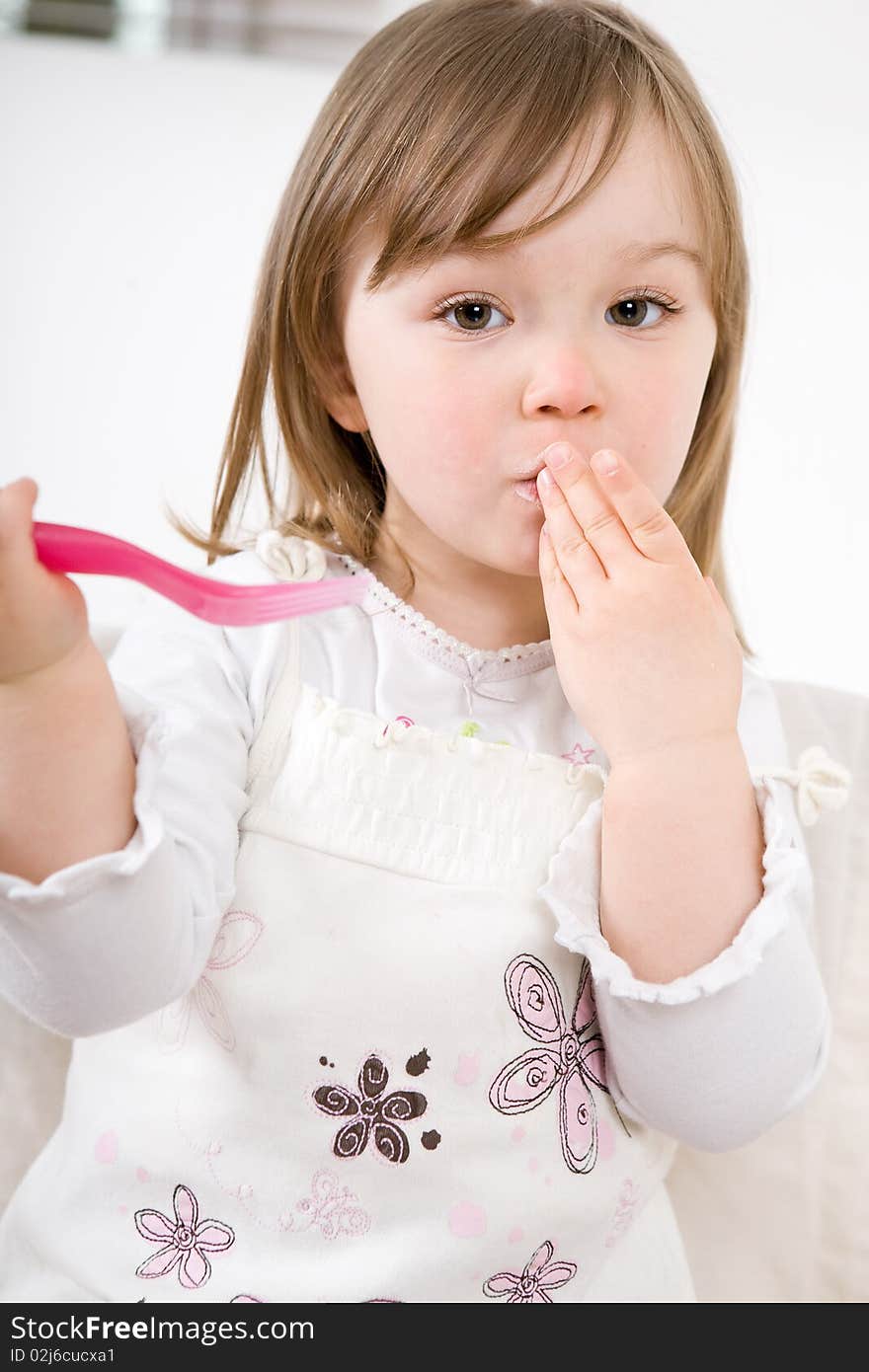 Sweet happy little girl eating