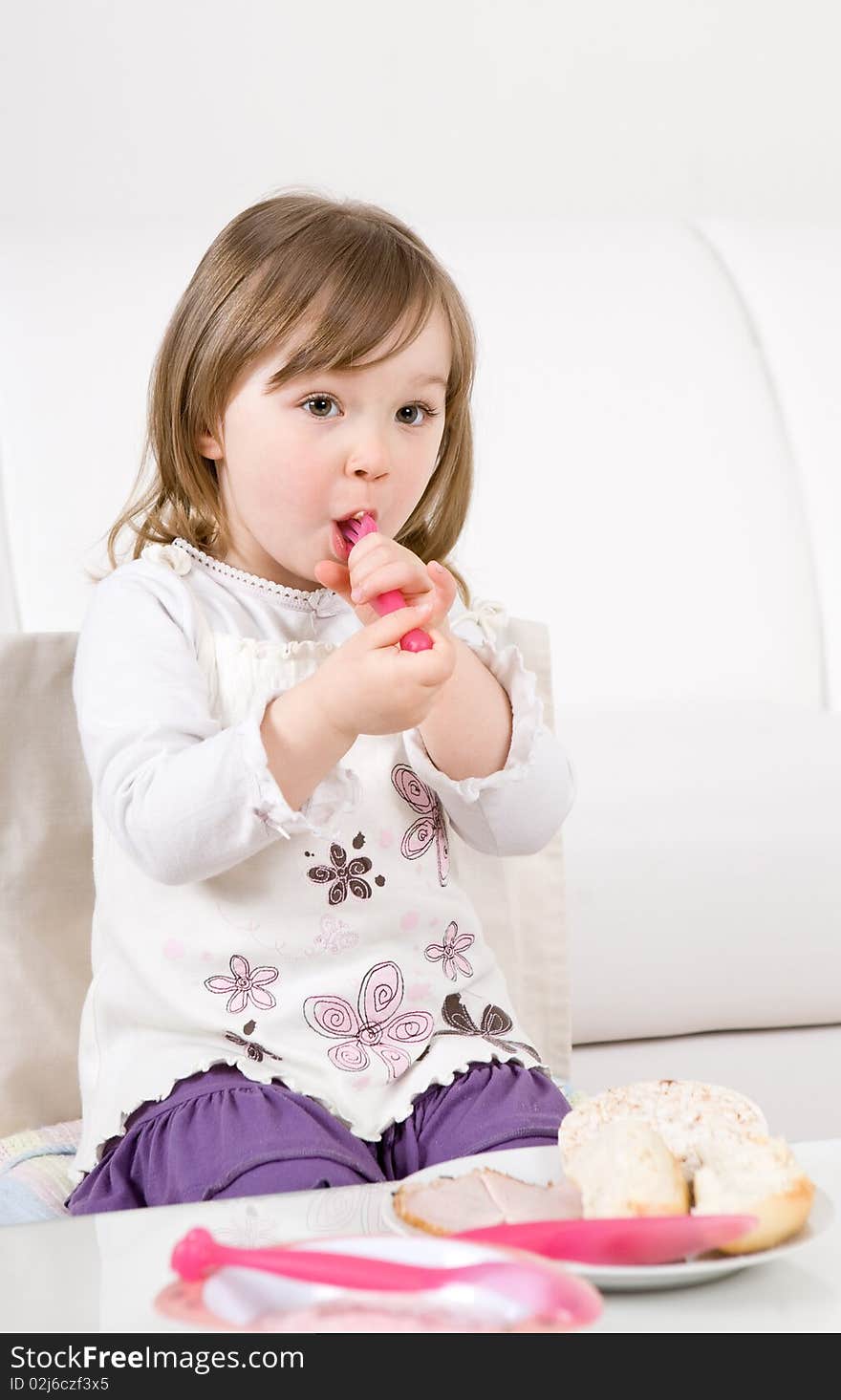 Sweet happy little girl eating