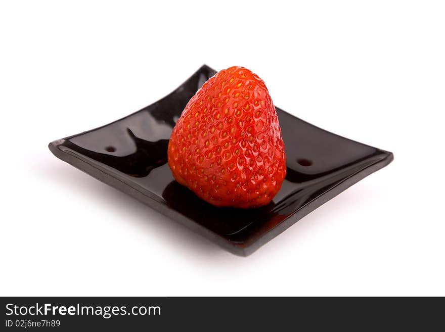 Strawberry on black plate isolated on white background