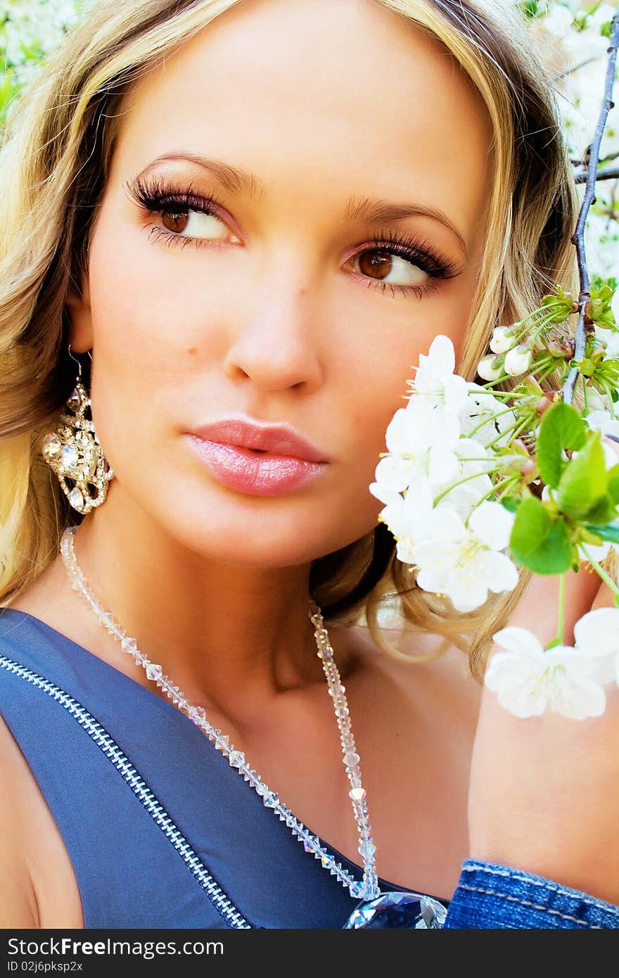 Portrait of a pretty woman with a cherry tree flowers