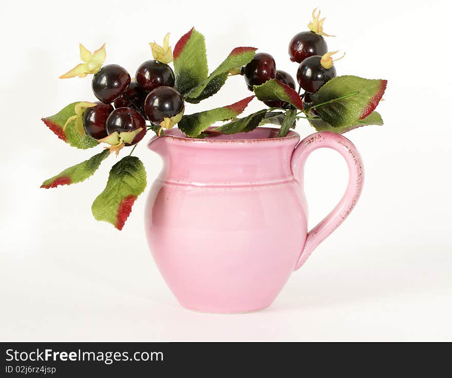 Pink ceramic jar with a sprig of souvenir berries