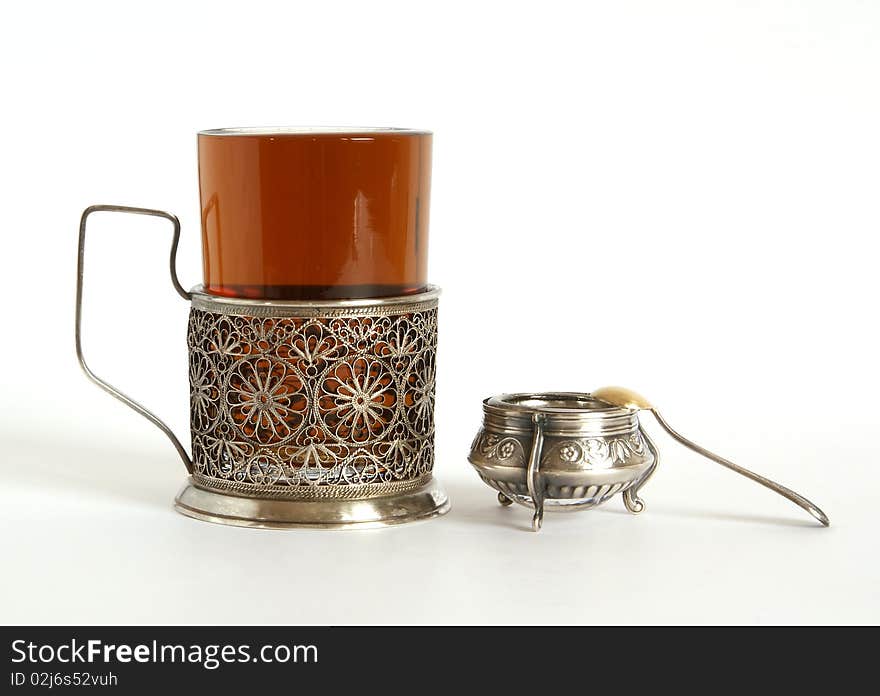 A glass of tea with a silver holder, isolated on a white background