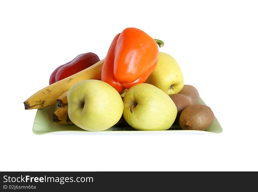 Still life with fruits and vegetables on a saucer on a white background