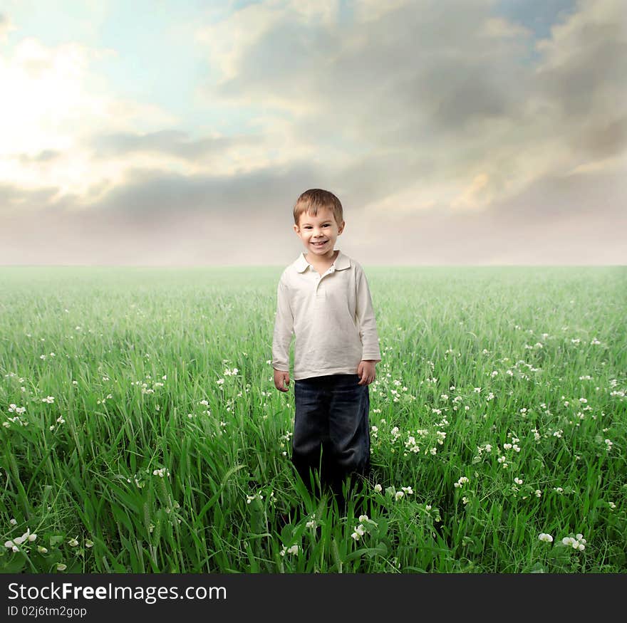 Smiling child standing on a green lawn. Smiling child standing on a green lawn