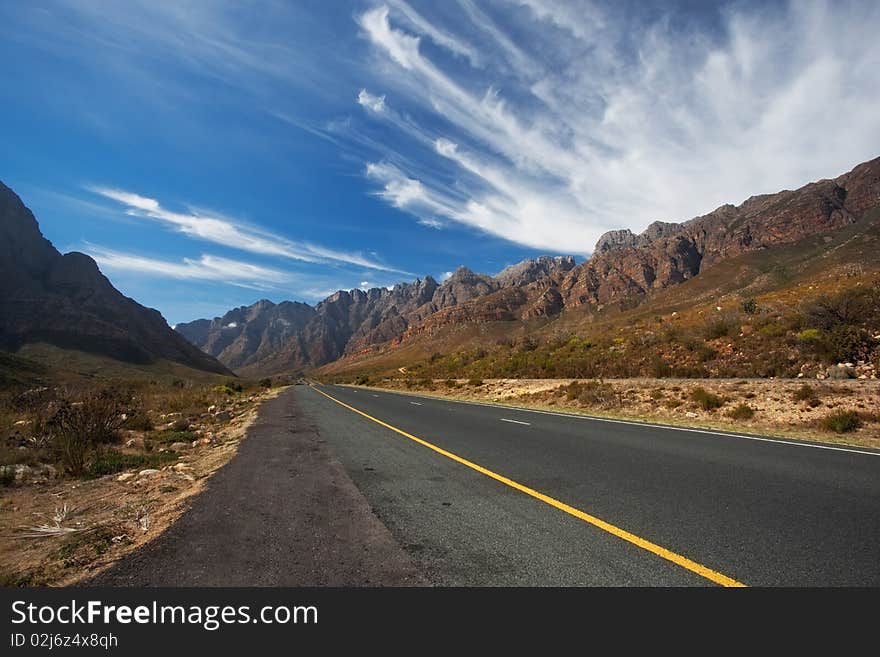 Road through the mountains in South Africa in the Western Cape with great High clouds. Road through the mountains in South Africa in the Western Cape with great High clouds