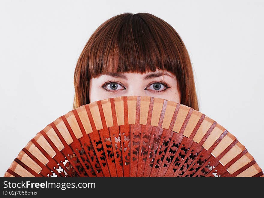 Portrait of beautiful woman holding Spanish fan in front of her face. Added film grain effect. Portrait of beautiful woman holding Spanish fan in front of her face. Added film grain effect