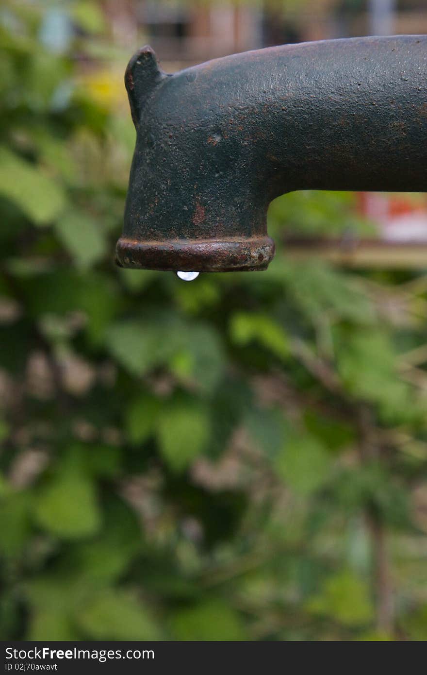 A Water-pump at an allotment taken at high speed to freeze the falling water. A Water-pump at an allotment taken at high speed to freeze the falling water