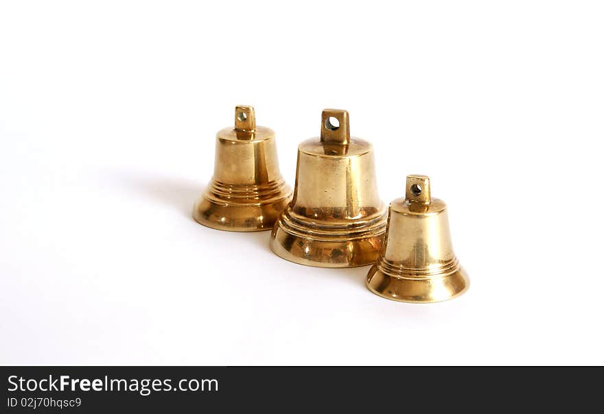 Small brass bells on a white background with shadows