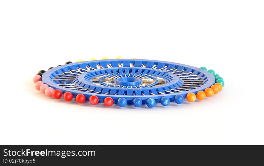 Set of tools for needlework (needle tailoring with colored heads), on a white background