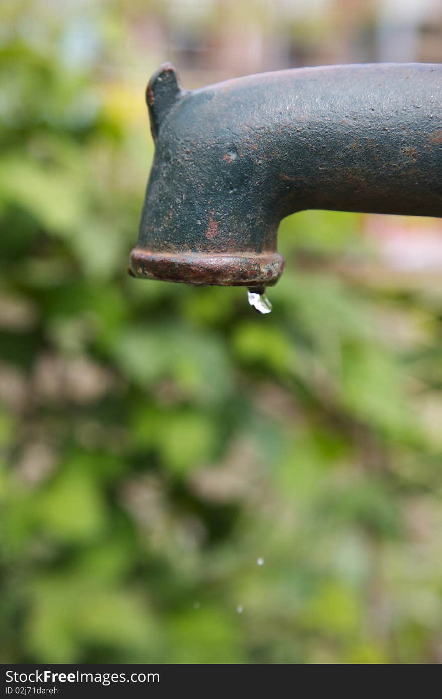 A Water-pump at an allotment taken at high speed to freeze the falling water. A Water-pump at an allotment taken at high speed to freeze the falling water