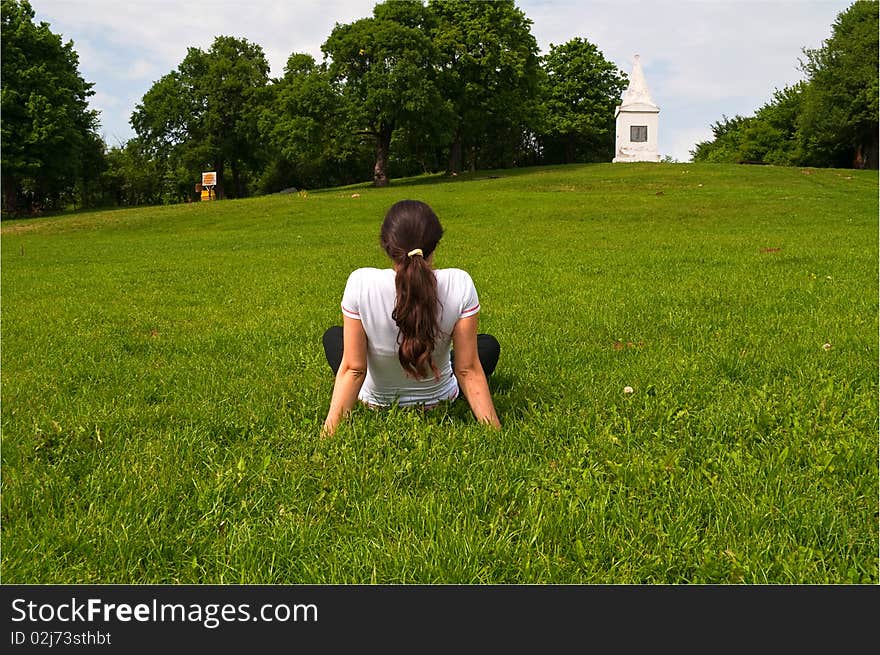 Young woman, sitting on the grass, enjoying nice spring weather outdoors. Young woman, sitting on the grass, enjoying nice spring weather outdoors