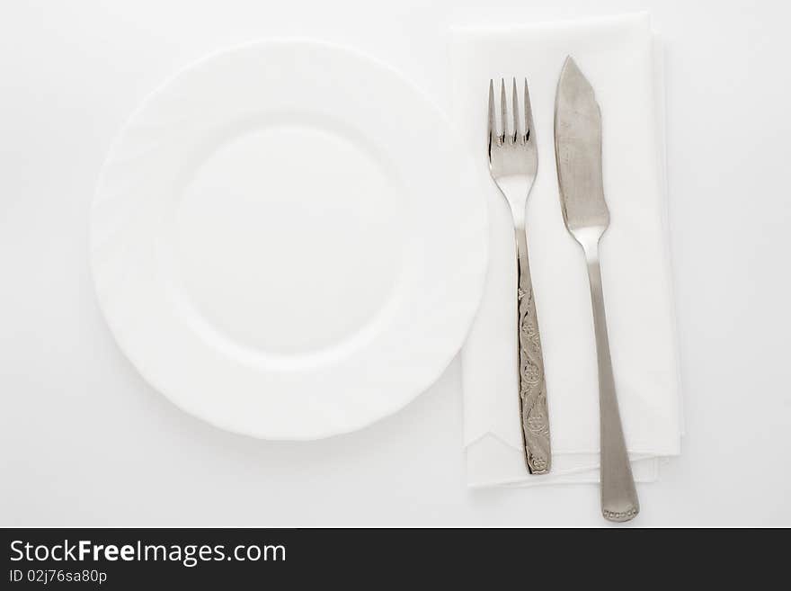 An image of white plate and knife with fork. An image of white plate and knife with fork