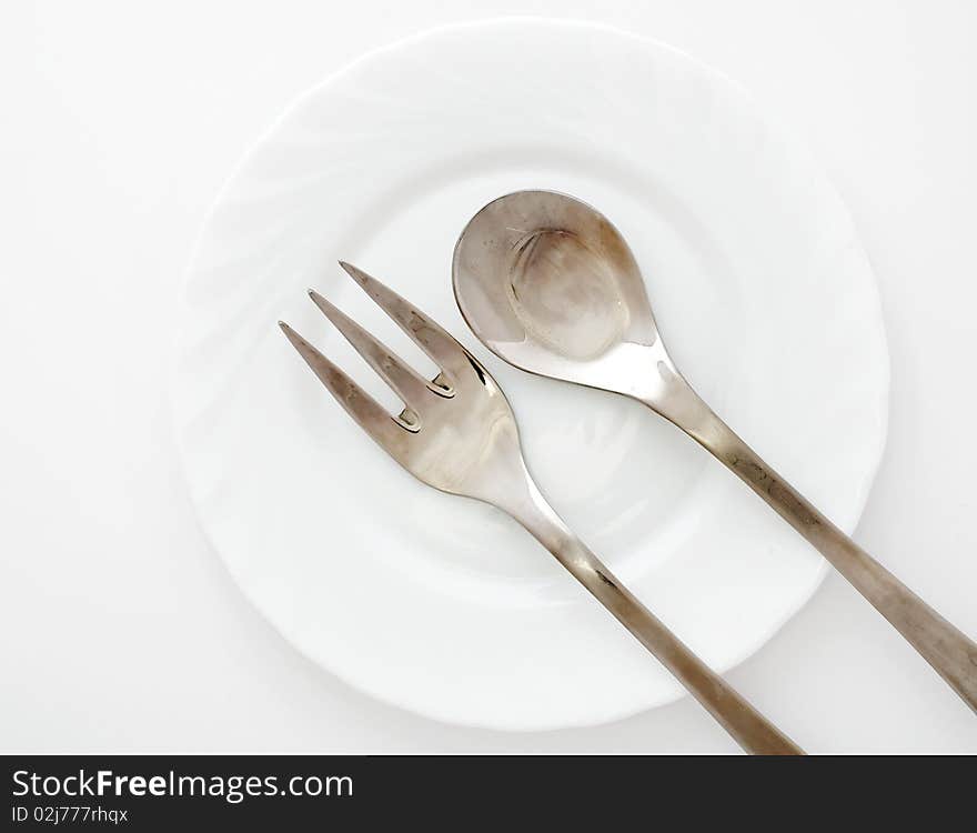 An image of fork and spoon on a plate