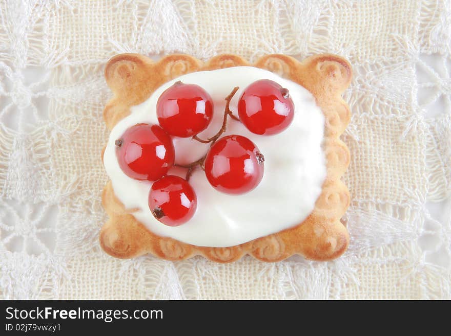 Dessert. Cake with red currant in sour cream on the white patterned napkin