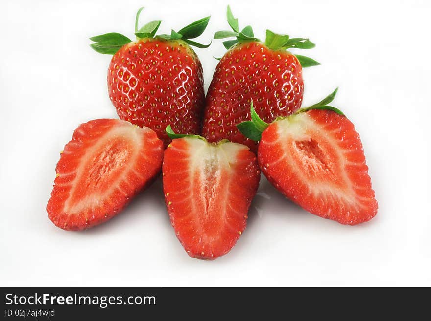 Whole and sliced strawberries closeup on white background