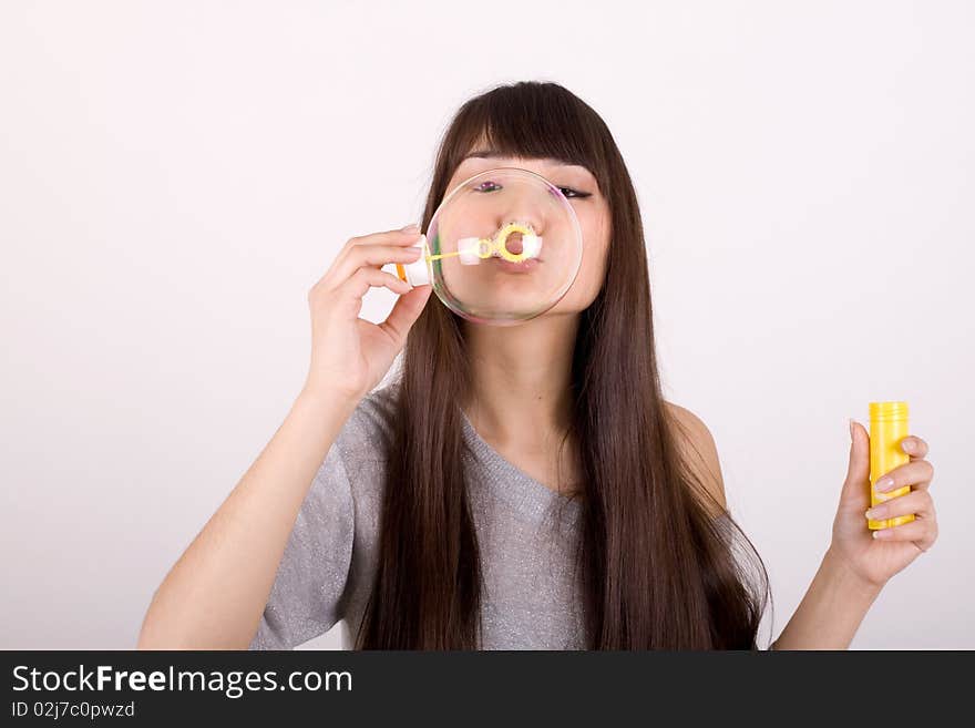 Girl blowing soap bubbles in studio