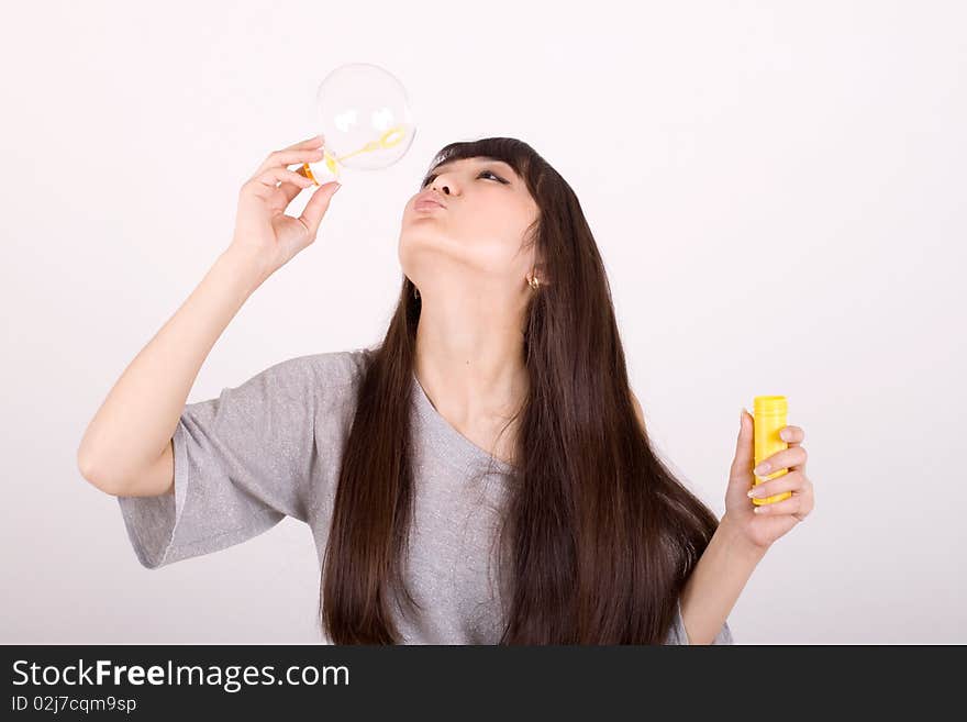 Girl blowing soap bubbles in studio