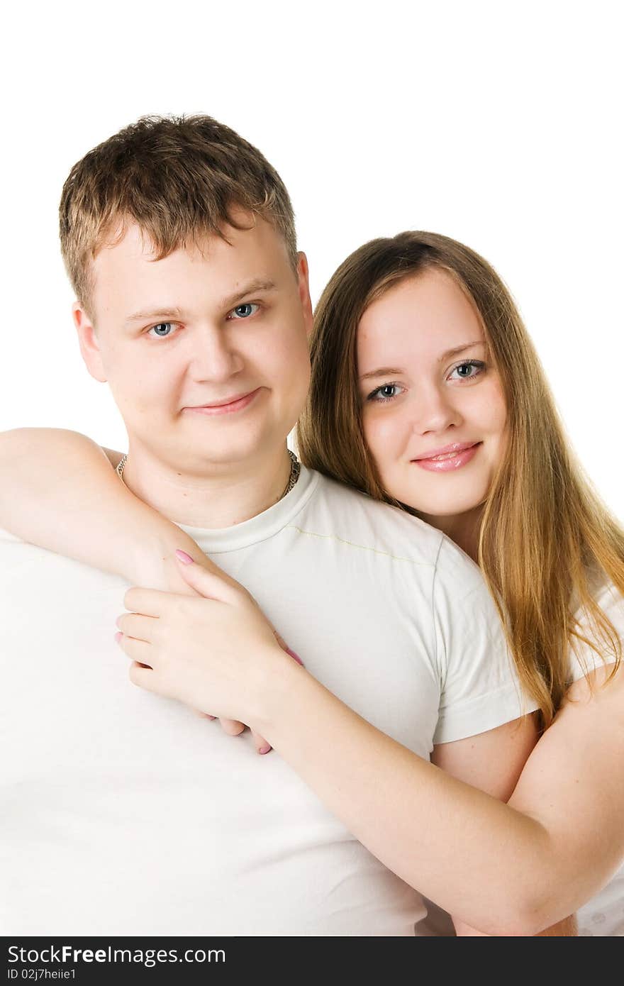 Young pair in white T-shirts, the girl embraces the man, isolated on white. Young pair in white T-shirts, the girl embraces the man, isolated on white