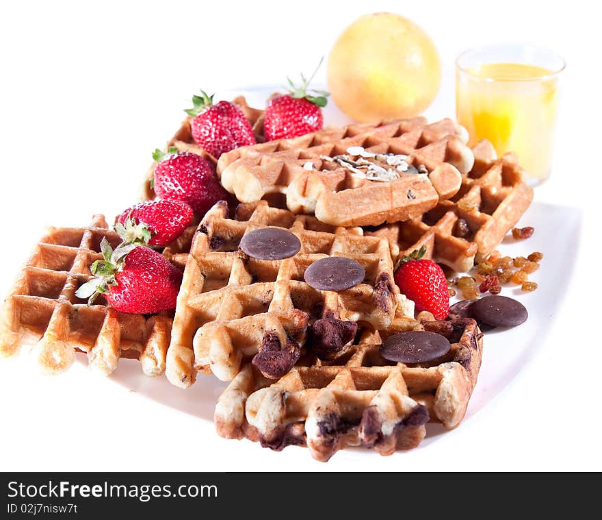 Fine decorated Waffles from integral wholegrain wiht strawberry , chocolate and dried grapes  on plate