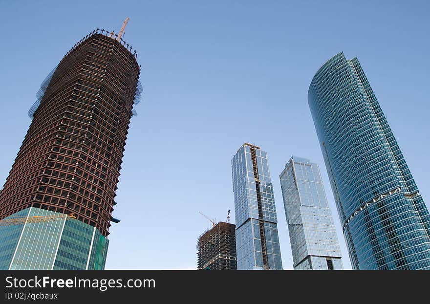 Skyscrapers with scaffolding over clear blue sky. Skyscrapers with scaffolding over clear blue sky