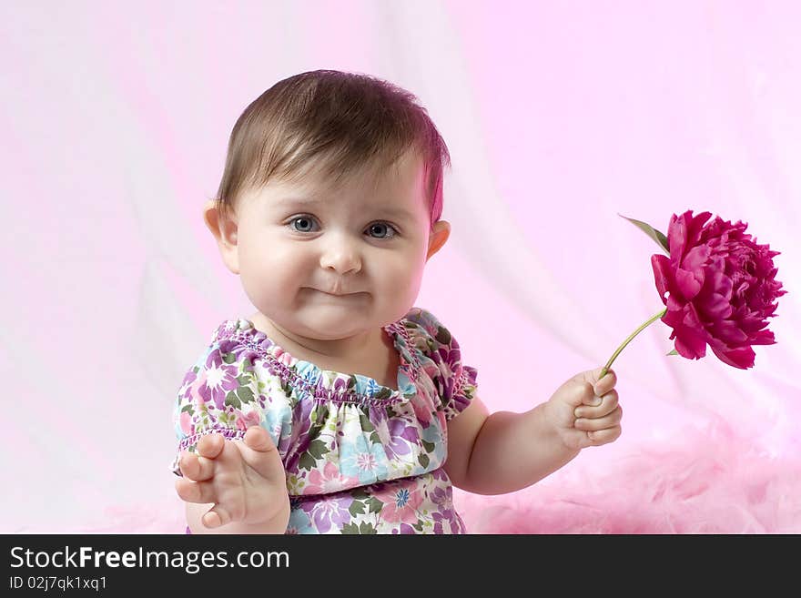 Baby girl with peony flower on pink background. Baby girl with peony flower on pink background