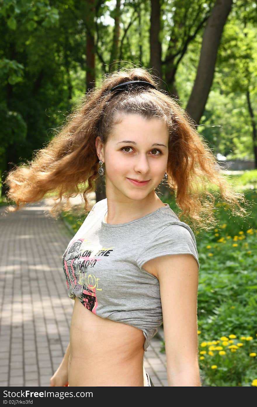 Smiling girl with turned hair in the park