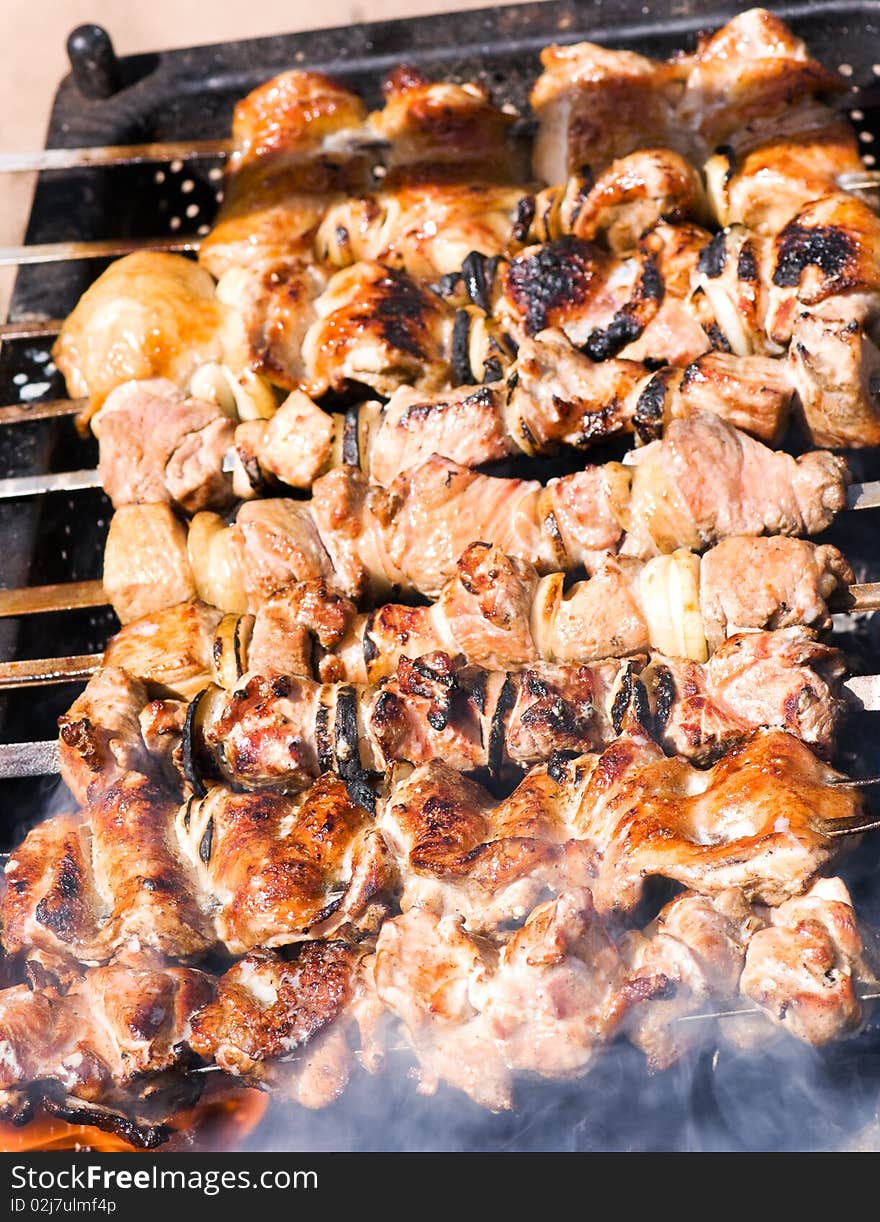 Big pieces of marinated pork and chicken on barbecue. Big pieces of marinated pork and chicken on barbecue