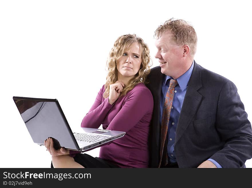 A business woman and man working together on a laptop he is happy about something and she is showing her frustration. A business woman and man working together on a laptop he is happy about something and she is showing her frustration.