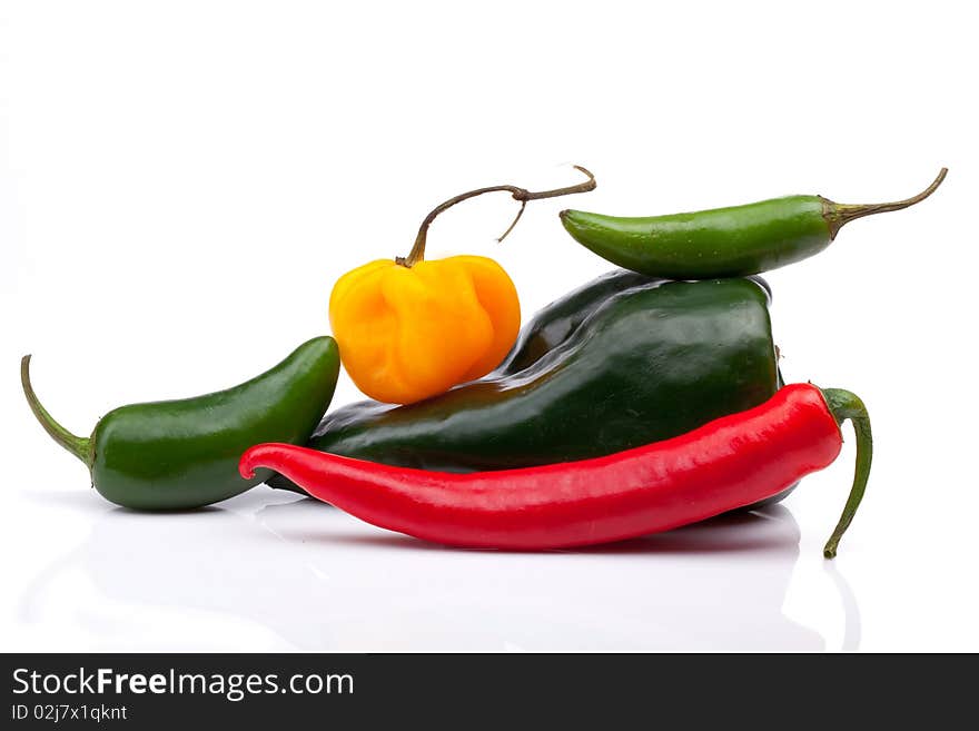 Five hot peppers in an interesting arrangement on a white background