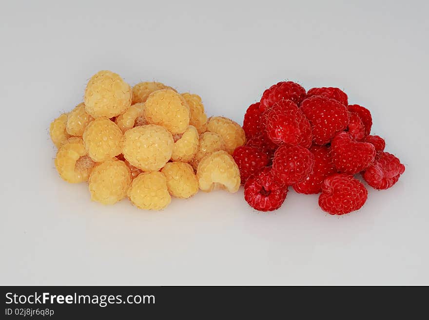 Red and golden raspberries isolated on white