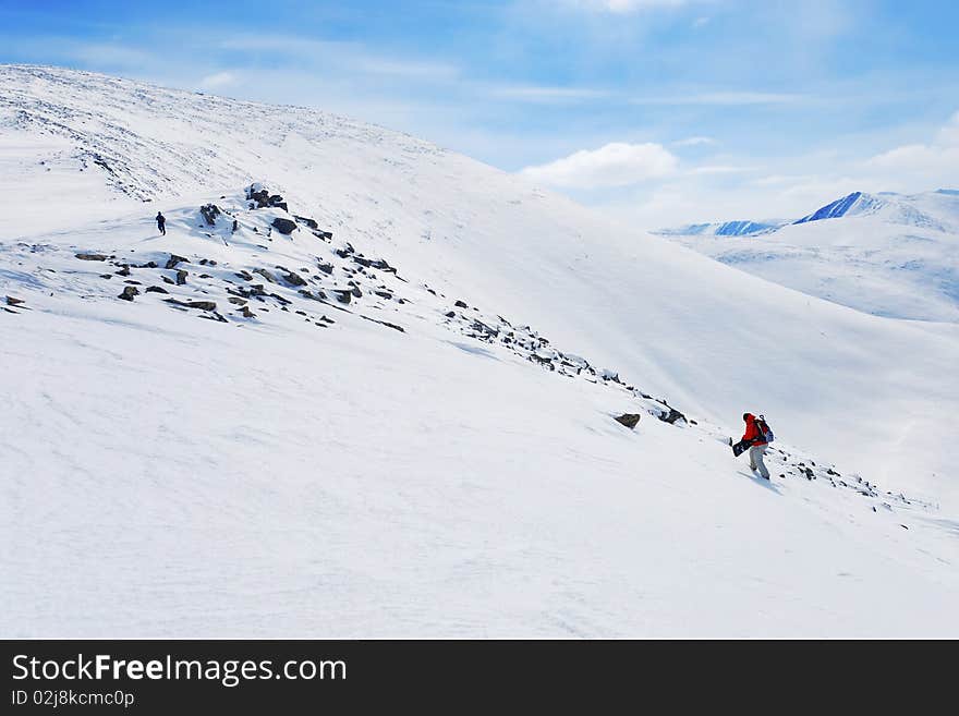 Backcountry snowboarder climbing up