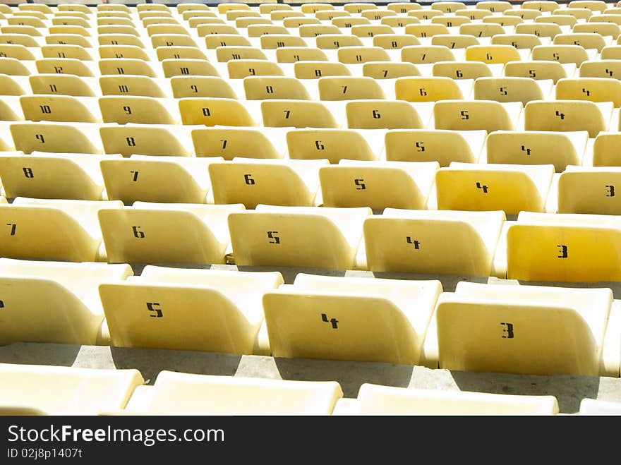 Rows of yellow chairs on a soccer stadium