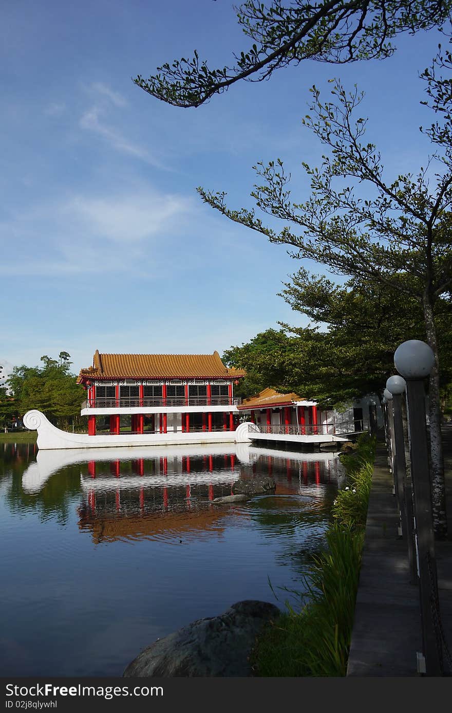 A beautiful stone boat with teahouse pavilion built above its deck sits on the lagoon at Chinese Garden