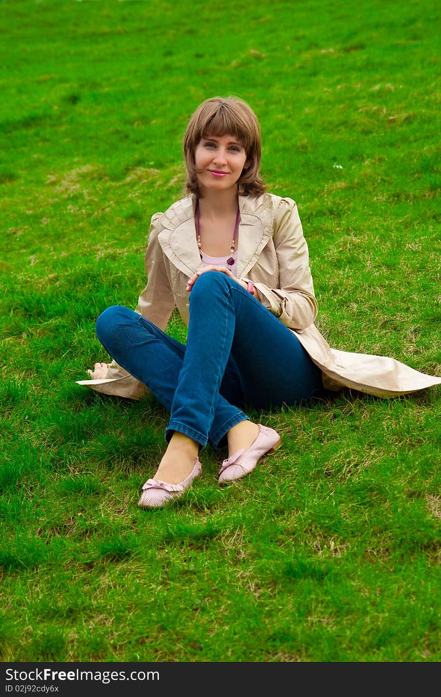 Woman sitting on green grass. Woman sitting on green grass