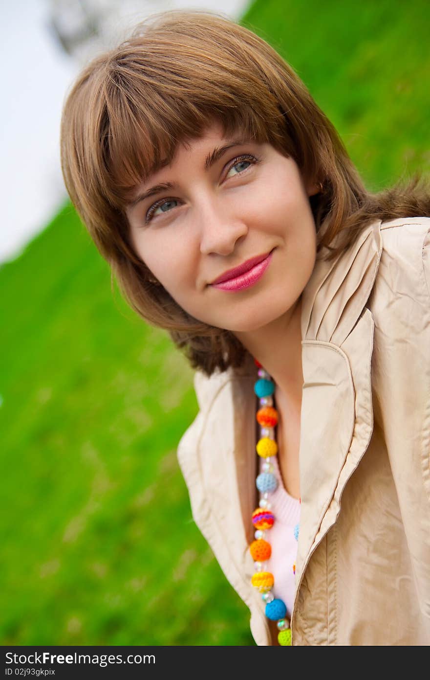 Woman's portrait with green grass on background. Woman's portrait with green grass on background