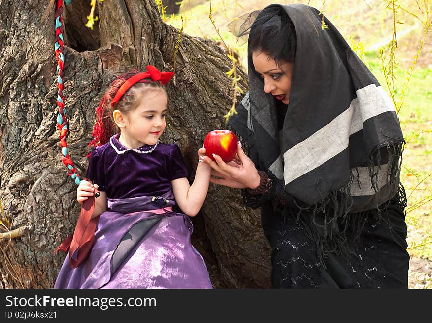 Stepmother gives poisoned apple give to snow white little girl. Stepmother gives poisoned apple give to snow white little girl