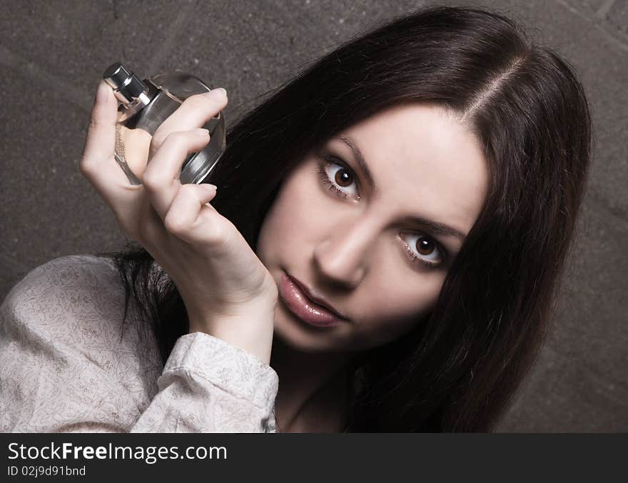 Beautiful lady with a bottle of perfume, face portrait