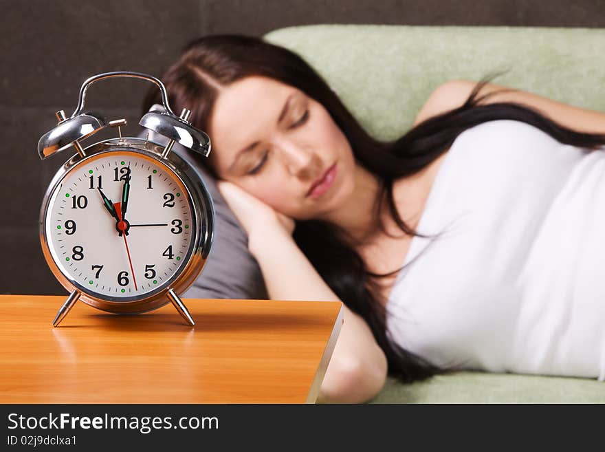 Vintage alarm clock, with beautiful young woman sleeping in the background. Vintage alarm clock, with beautiful young woman sleeping in the background