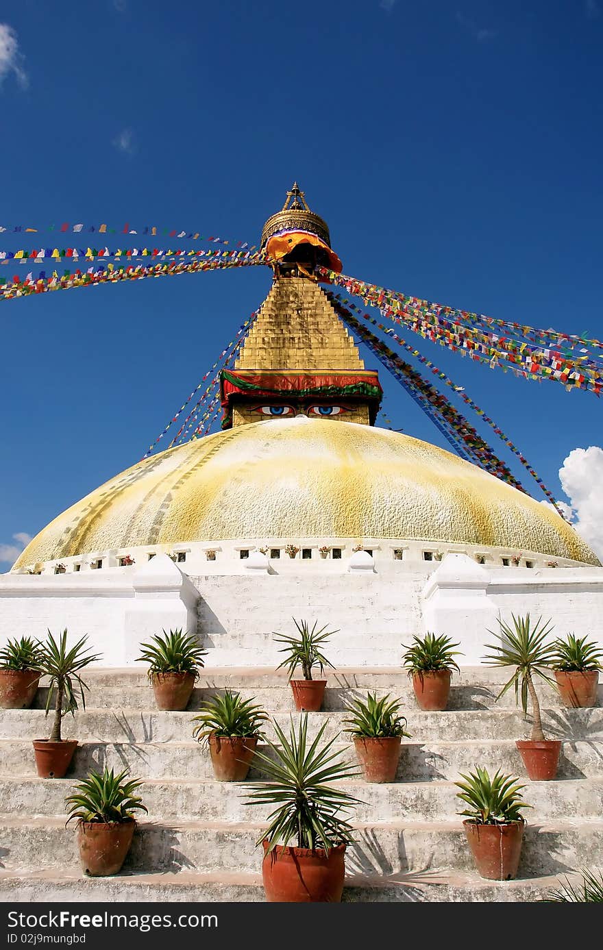 Bodhnath stupa in kathmandu with buddha eyes and prayer flags on clear blue sky background