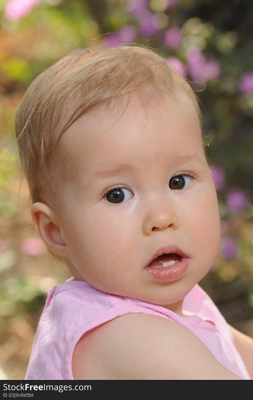 Baby sit in a garden on a bench in the afternoon